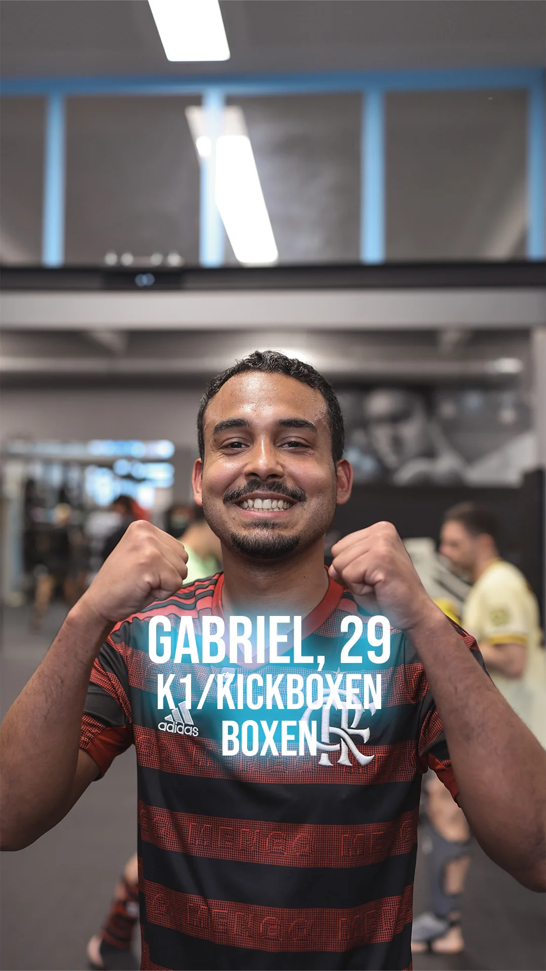 Gabriel, 29, lächelnd in Boxhaltung im Gym