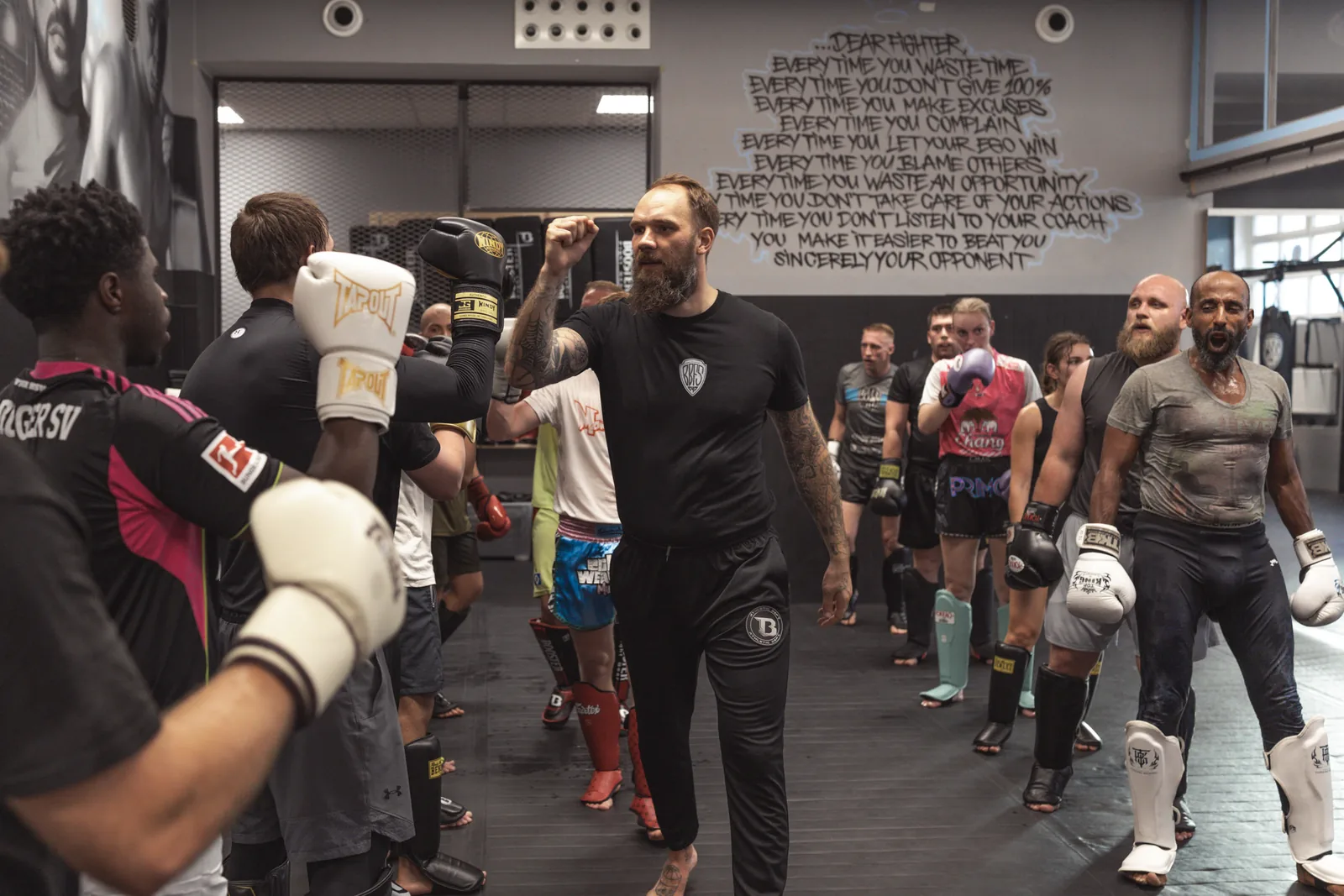 Trainer führt die volle Trainingsgruppe durch das Abgrüßen in der Halle
